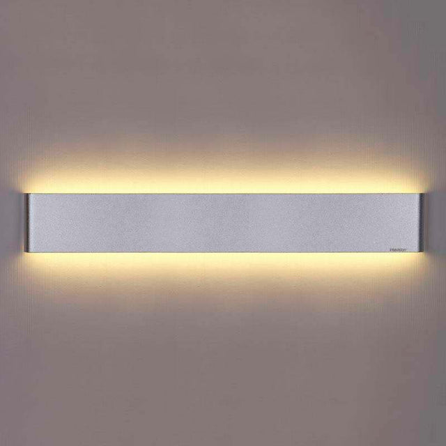 Elegante aplique LED de pared en color plata de diseño minimalista. Permite generar un tipo de luz difusa y homogénea a la vez, son elementos funcionales y decorativos. Los apliques de pared Led suelen ser luminarias que complementan a la iluminación principal siendo un elemento importante en la decoración de los más variados ambientes.