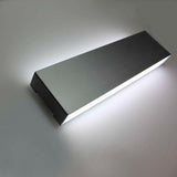 Aplique LED de pared funcional y decorativo de diseño moderno y minimalista en color plata. Permite generar un tipo de luz difusa y homogénea. Los apliques de pared Led suelen ser luminarias que complementan a la iluminación principal siendo un elemento importante en la decoración de los más variados ambientes.  Incluye mando a distancia RF para apagar/encender, controlar la intensidad, color y efectos de la luz.