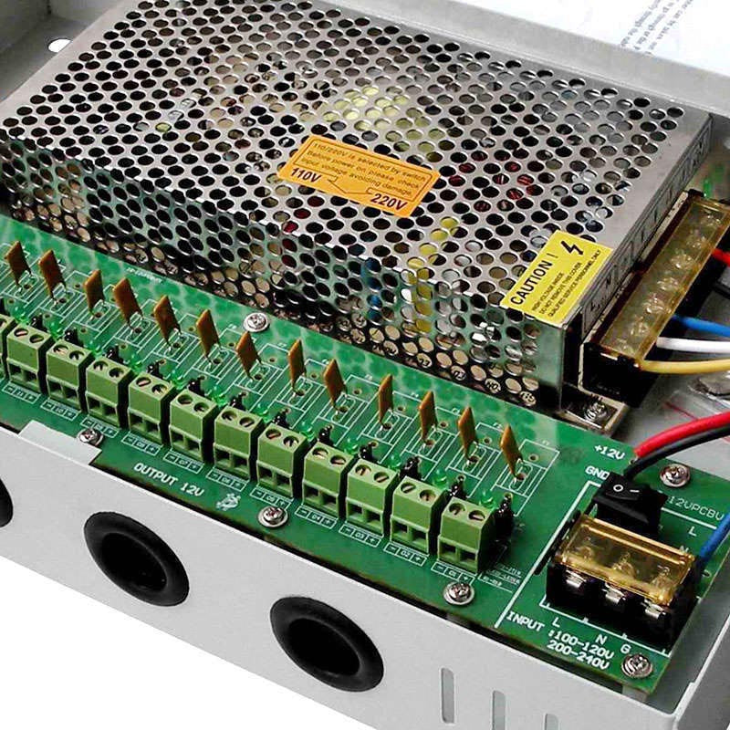 Caja metálica con fuente de alimentación y panel con 18 puertos de conexión, voltaje de salida ajustable ±10%, dimensiones reducidas, refrigeración de la fuente por convección natural y protección contra sobrecargas y sobretensiones.