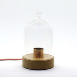 Fanal decorativo LED Bell JAR, una luminaria evocadora del recuerdo de décadas pasadas, una lámpara que muestra la simplicidad del primer emisor de luz. Una bombilla filamentosa ególatra, protegida por un fanal de vidrio.